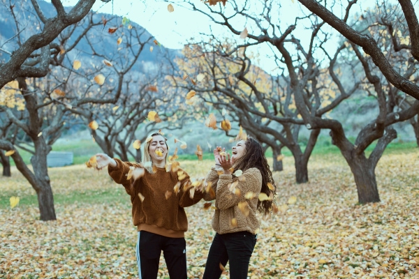 Sisters enjoying the autumn leaves